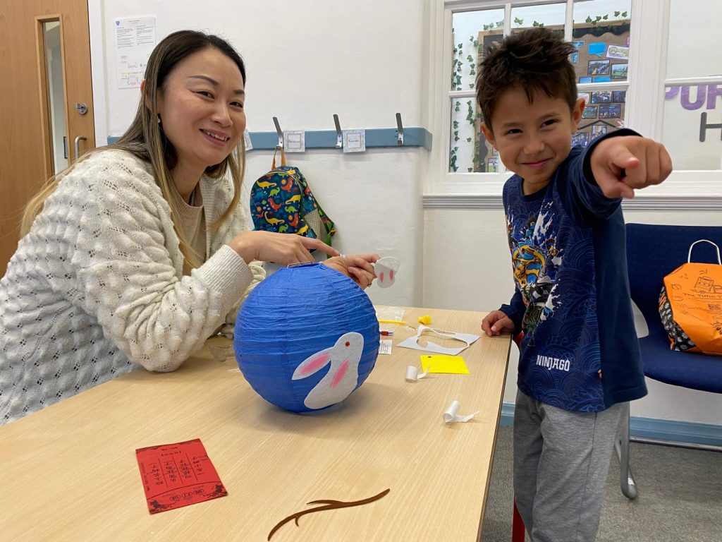Teacher Jie Bian, and a student laugh together