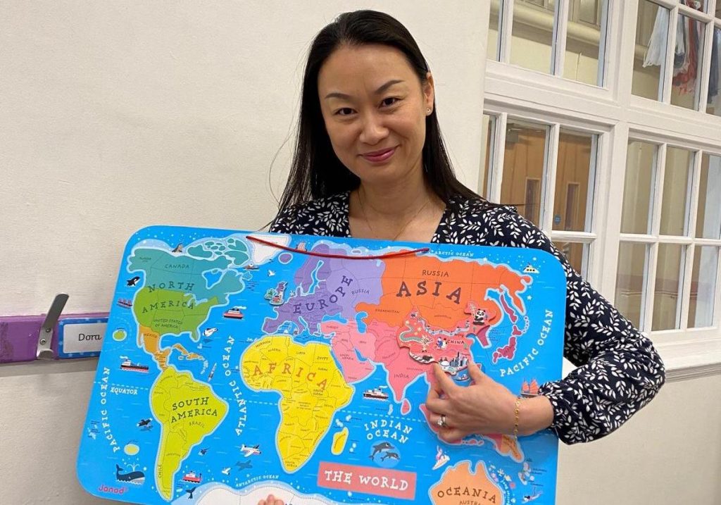 Teacher Jie BIan, points to China on a world map